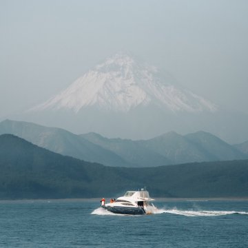 boat on the water with a mountain in the background 